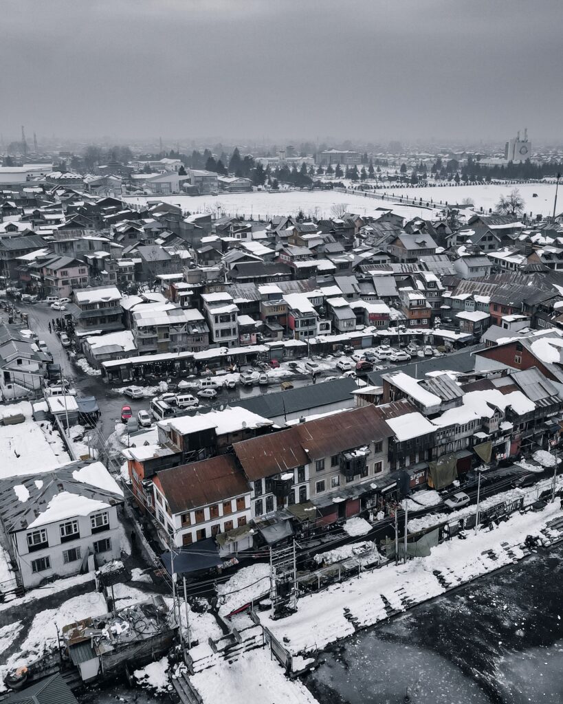 Drone shot of a snowy Srinagar cityscape in winter showcasing urban architecture from above.